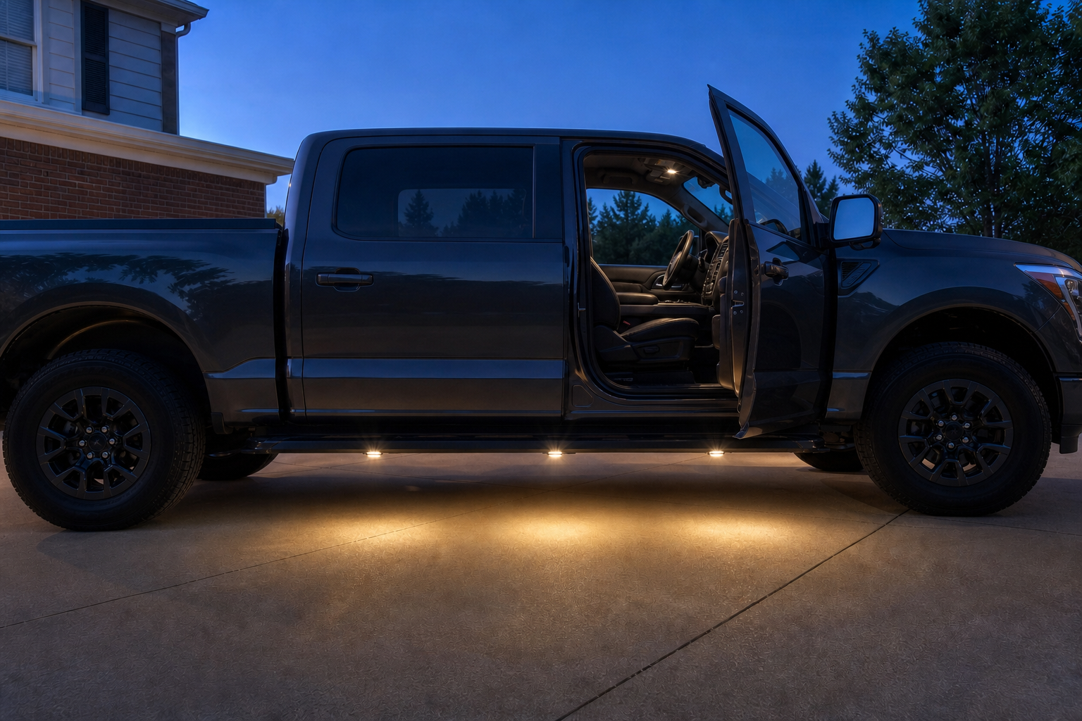Warm-white running board courtesy lights illuminating the step and ground beside a pickup truck