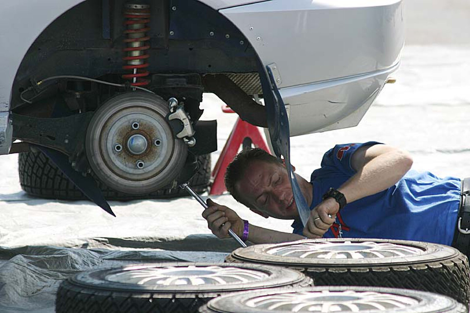 Mechanic working beneath a vehicle supported by jack stands