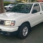 White Nissan Frontier pickup truck shown from the front left