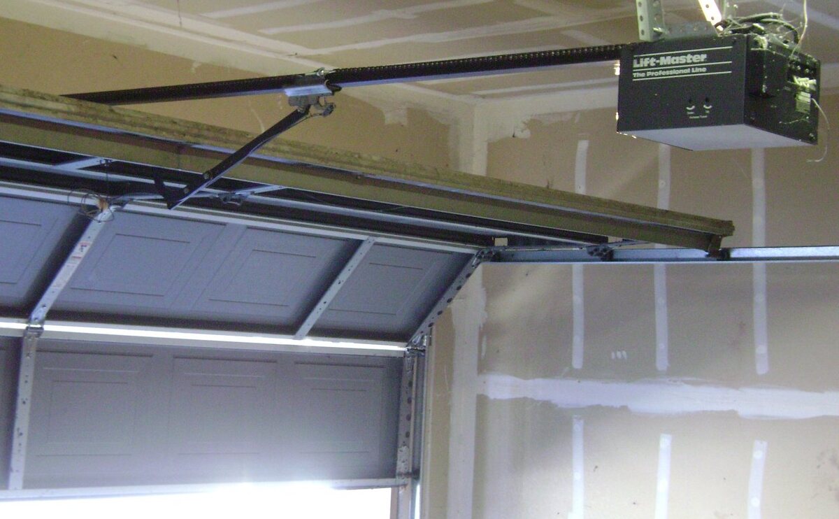 Chain-drive garage door opener mounted above a residential garage door