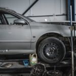 Vehicle positioned on an automotive lift in a repair shop