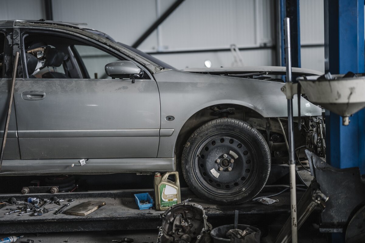 Vehicle positioned on an automotive lift in a repair shop