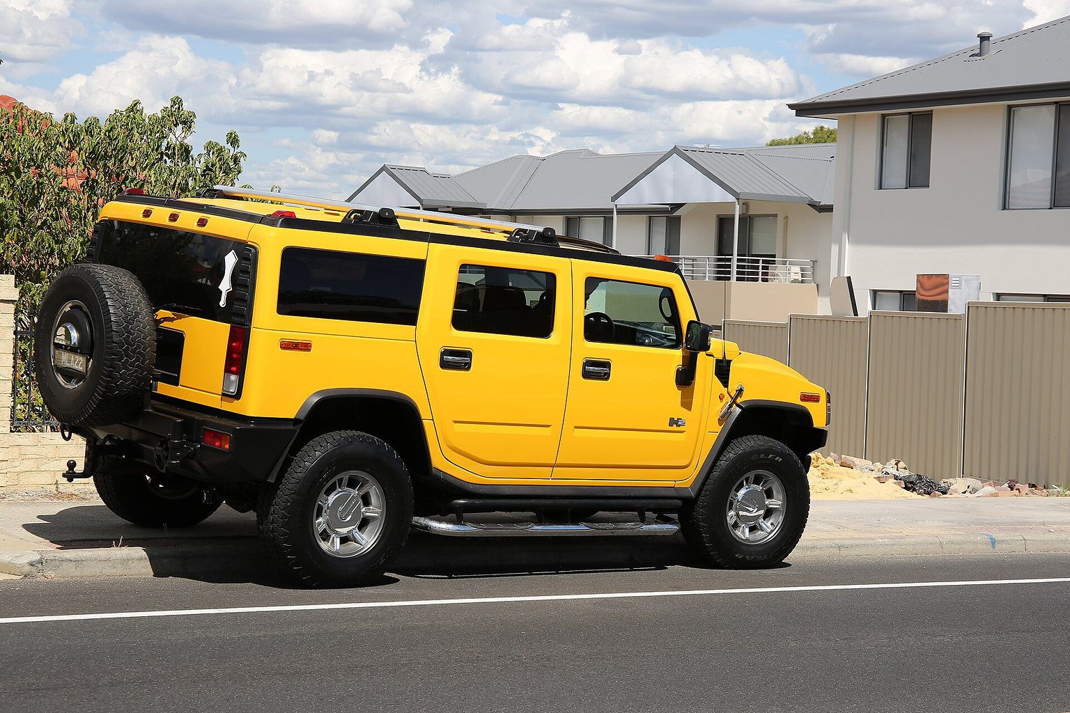 Yellow Hummer H2 SUV shown from the side