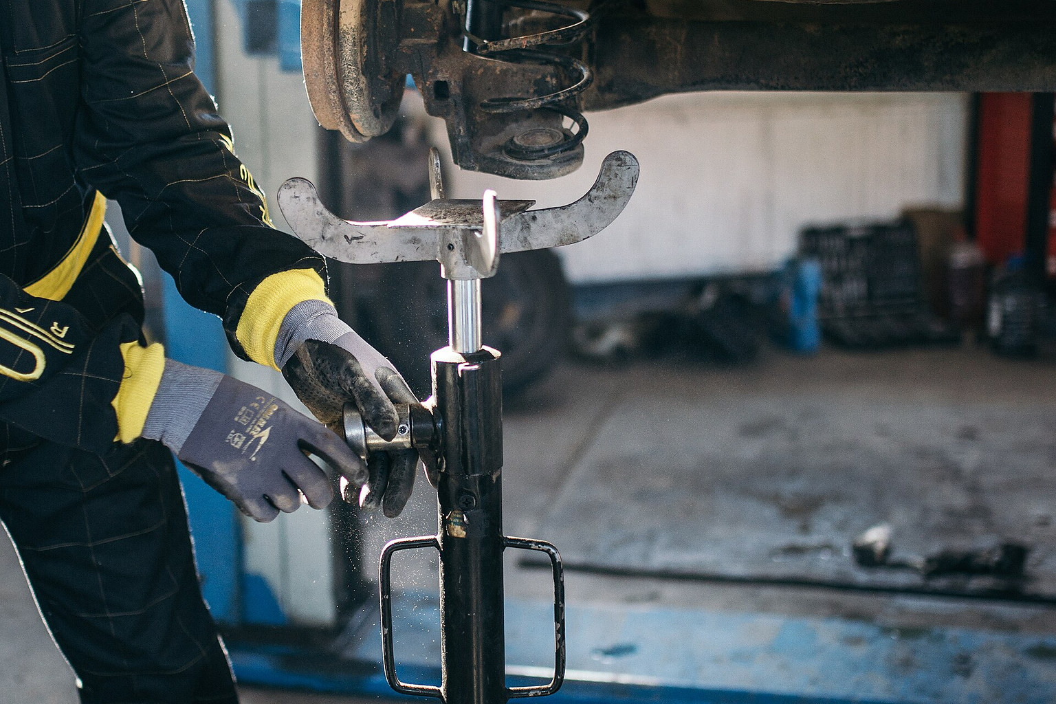 Mechanic using a spring compressor during vehicle suspension repair