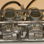 Row of motorcycle carburetors viewed from above