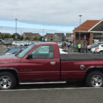 Red Dodge Ram 1500 pickup truck in side view