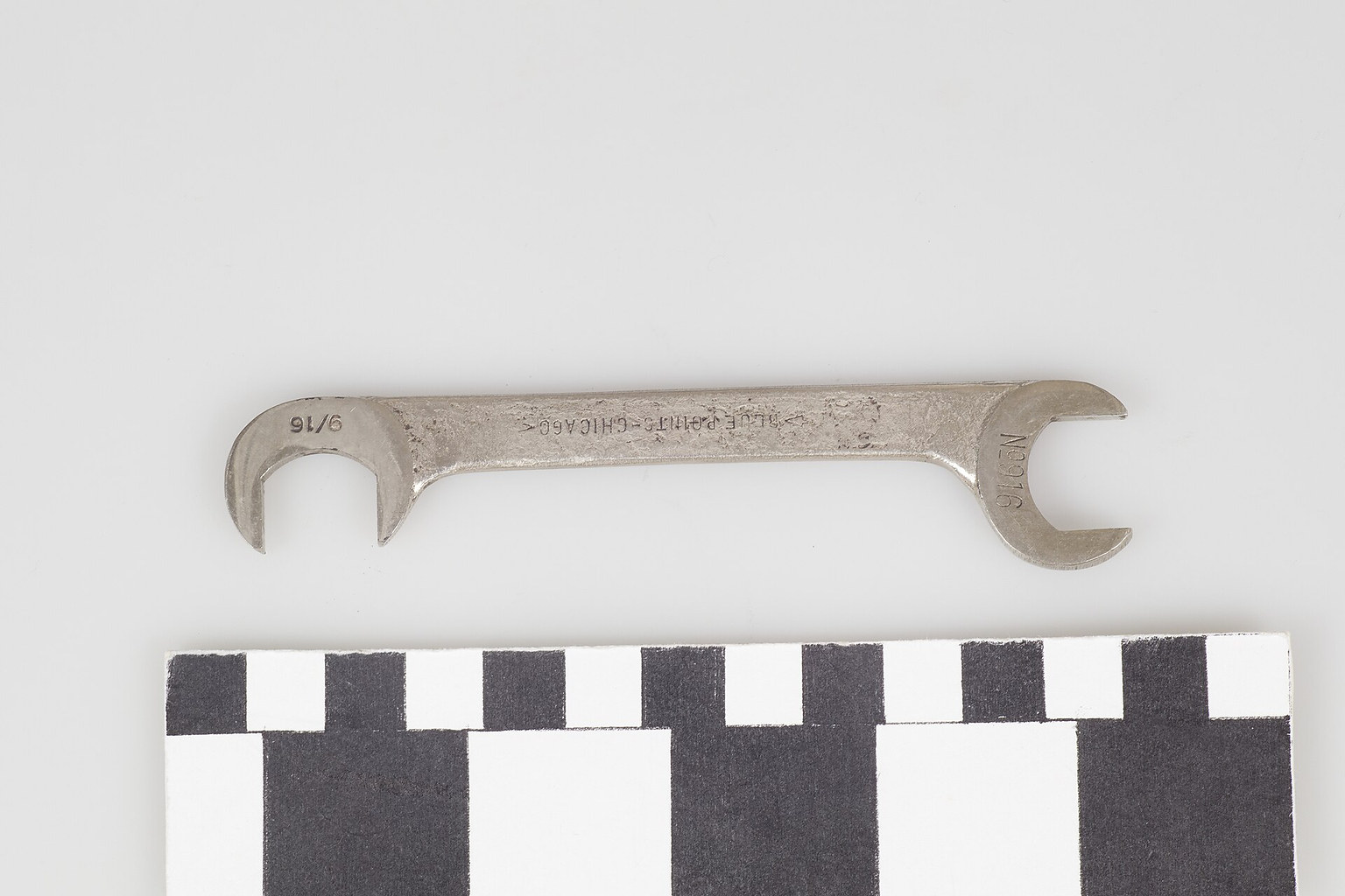 Open-end carburetor wrench on a measurement background